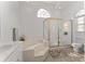 Bright bathroom featuring soaking tub with gold-trimmed shower and arched window at 5819 Ne 72Nd St, Silver Springs, FL 34488