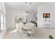 Bright dining room with white furniture, chandelier, and adjacent sitting room with piano at 5819 Ne 72Nd St, Silver Springs, FL 34488