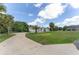 Landscaped front yard with mature palm trees, spacious driveway, and inviting one-story home with an arched front entrance at 5819 Ne 72Nd St, Silver Springs, FL 34488