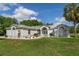 Beautiful one-story home featuring manicured front lawn, mature palm trees, and a welcoming front entrance with arched windows at 5819 Ne 72Nd St, Silver Springs, FL 34488