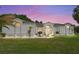 Inviting one-story home with well-maintained lawn, elegant landscaping, and a charming front entrance with arched windows at sunset at 5819 Ne 72Nd St, Silver Springs, FL 34488