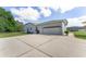 Home features a two-car attached garage, a convenient side door, a lawnmower, and plenty of parking on an expansive driveway at 5819 Ne 72Nd St, Silver Springs, FL 34488