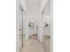 Hallway with closet space leading to bright white bathroom with double vanity and a shower-tub combo at 5819 Ne 72Nd St, Silver Springs, FL 34488