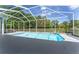 Clear blue screened in pool with surrounding greenery and pool deck at 5819 Ne 72Nd St, Silver Springs, FL 34488