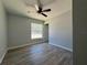 Bright bedroom with wood-look flooring, ceiling fan, and a large window for natural light at 6101 Sw 206Th Ave, Dunnellon, FL 34431