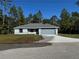 Charming single-story home with a well-manicured lawn, gray exterior, and an attached two-car garage at 6101 Sw 206Th Ave, Dunnellon, FL 34431
