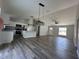 Open-concept living space with modern gray floors, white cabinets, granite counters and plenty of natural light at 6101 Sw 206Th Ave, Dunnellon, FL 34431
