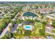 Aerial view of a community pool and nearby lake surrounded by homes at 680 Farmington Ave, The Villages, FL 32162