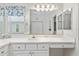 Bathroom with a large mirror, white countertop, and ample storage at 680 Farmington Ave, The Villages, FL 32162