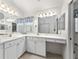 Bright bathroom featuring double sinks, ample counter space, and white cabinetry at 680 Farmington Ave, The Villages, FL 32162