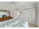 Bright bedroom with closet, ceiling fan, neutral walls, and floral bedding at 680 Farmington Ave, The Villages, FL 32162