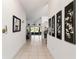 Bright hallway with tile flooring, decorative wall art, and views of the living area and outdoor space at 680 Farmington Ave, The Villages, FL 32162