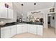 Bright kitchen features black granite countertops, white cabinetry, and stainless steel sink at 680 Farmington Ave, The Villages, FL 32162