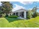 Back exterior view of home with screened lanai and lush landscaping at 680 Farmington Ave, The Villages, FL 32162