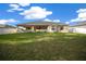 Backyard features a large grassy area and a covered patio ideal for relaxing outdoors at 7370 Sw 129Th Ln, Ocala, FL 34473