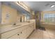 A luxurious bathroom features dual sinks, a glass shower, and a relaxing soaking tub at 7370 Sw 129Th Ln, Ocala, FL 34473