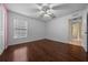 Bright bedroom with laminate floors, ceiling fan, window and an open door at 7370 Sw 129Th Ln, Ocala, FL 34473