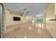Large, bright living room with neutral walls, tile flooring, ceiling fan, and natural light at 7370 Sw 129Th Ln, Ocala, FL 34473