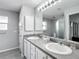 Well-lit bathroom with a double sink vanity, large mirror, and a walk-in shower at 7474 Se 172Nd Fieldcrest St, The Villages, FL 32162