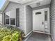 Bright front door with decorative glass and sidelight, complemented by manicured landscaping at 7474 Se 172Nd Fieldcrest St, The Villages, FL 32162