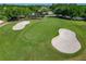 Aerial view of the green with a sand trap surrounding a lush golf course at 7474 Se 172Nd Fieldcrest St, The Villages, FL 32162