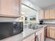 Cozy kitchen featuring a breakfast bar and stainless steel appliances and light wood cabinets at 7474 Se 172Nd Fieldcrest St, The Villages, FL 32162