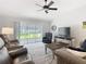 Bright living room with sliding glass door, ceiling fan, and stylish decor at 7474 Se 172Nd Fieldcrest St, The Villages, FL 32162
