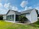 Exterior view of the glass-enclosed sunroom and well-maintained backyard at 7474 Se 172Nd Fieldcrest St, The Villages, FL 32162