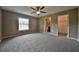 Bedroom featuring a ceiling fan, ensuite bathroom, walk-in closet, and a window at 861 Sw Fig Tree Ln, Dunnellon, FL 34431