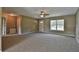 Spacious living room features neutral carpeting, a ceiling fan, and lots of natural light at 861 Sw Fig Tree Ln, Dunnellon, FL 34431
