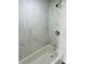 Bathroom featuring bathtub with marble tile surround and chrome fixtures at 9247 Se 142Nd Pl, Summerfield, FL 34491