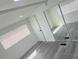 Bright bedroom with wood floors, modern mirrored closet, and white trim at 9247 Se 142Nd Pl, Summerfield, FL 34491