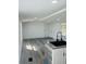 Bright kitchen with gray wood floor, white walls, a modern sink and a view through a window at 9247 Se 142Nd Pl, Summerfield, FL 34491