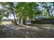 A view of the backyard of a modest home with a side yard with a grassy area and trees at 935 Ne Sanchez Ave, Ocala, FL 34470