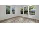 This bedroom features three windows and wood-look flooring at 935 Ne Sanchez Ave, Ocala, FL 34470