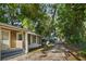 A view of the side of a modest home with light brown siding and a glimpse of a driveway at 935 Ne Sanchez Ave, Ocala, FL 34470