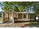 Charming single-story home with brown siding, a covered porch, and a mature tree in the front yard at 935 Ne Sanchez Ave, Ocala, FL 34470