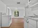 A kitchen with white cabinets, laminate floors, modern appliances and a view to the living room at 935 Ne Sanchez Ave, Ocala, FL 34470
