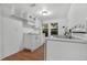 A well-lit kitchen with white cabinets, laminate floor and modern white appliances at 935 Ne Sanchez Ave, Ocala, FL 34470