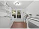 A well-lit kitchen with white cabinets, a laminate floor and modern white appliances at 935 Ne Sanchez Ave, Ocala, FL 34470