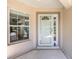 Welcoming front entrance featuring a storm door, a window, and a neutral color scheme at 9541 Sw 93Rd Loop, Ocala, FL 34481