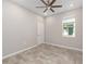 Bright bedroom featuring a ceiling fan, tiled floors, a window, and a white door at 9697 Sw 102Nd Ter, Ocala, FL 34481