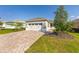 Charming single-story home featuring a two-car garage, brick paver driveway, and manicured lawn at 9697 Sw 102Nd Ter, Ocala, FL 34481