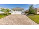 Two-car garage with brick paver driveway and well-maintained lawn at 9697 Sw 102Nd Ter, Ocala, FL 34481