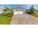Spacious two-car garage with brick paver driveway and manicured lawn at 9697 Sw 102Nd Ter, Ocala, FL 34481