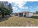 A backyard with mature trees and shrubs surrounds a home with a sunroom and screened in porch at 10141 Sw 62Nd Terrace Rd, Ocala, FL 34476
