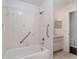 The bathroom features a white tiled shower and bathtub with safety bars for accessibility at 10141 Sw 62Nd Terrace Rd, Ocala, FL 34476