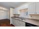 Well-maintained kitchen with white cabinets, double sink, and view to the adjacent dining area at 10141 Sw 62Nd Terrace Rd, Ocala, FL 34476
