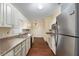 Galley kitchen featuring stainless steel appliances, ample cabinets, and wood flooring at 10141 Sw 62Nd Terrace Rd, Ocala, FL 34476