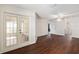 Bright living room featuring dark wood floors and glass doors leading to the backyard at 10141 Sw 62Nd Terrace Rd, Ocala, FL 34476